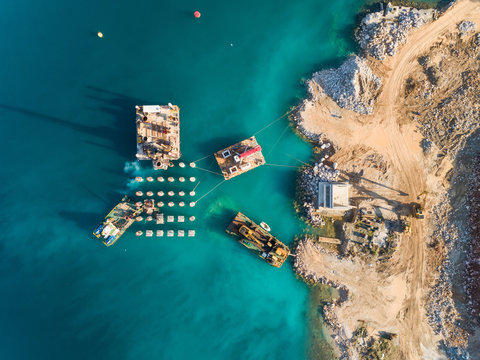 Aerial view of machinery on concrete platforms at the construction of future LNG terminal on the shore of the bay in Omisalj, Croatia
