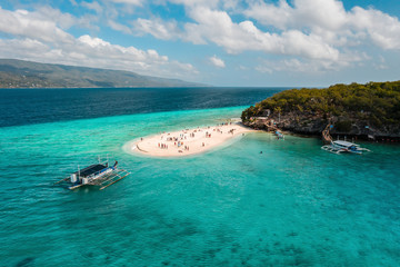 Aerial view of Sumilon Island's famous white sand bar in Oslob, Cebu, Philippines that attracts visitors every day because of its magnificent white sand beach and crystal-clear waters.