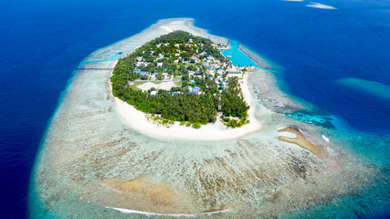 Aerial view of local island Omadhoo, located in Alif Dhaal Atoll, Maldives, Indian Ocean with reef, harbour, local beach and sandbank