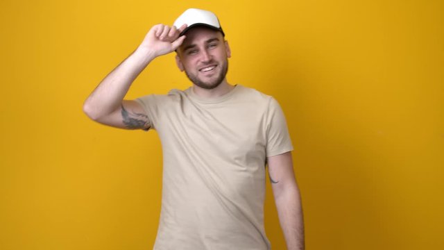 Handsome man choosing cap against color background