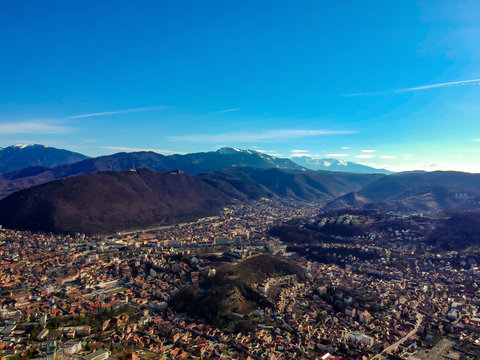 Aerial view of Brasov City with the Bucegi mountain range in the distance, Romania