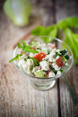 fresh cottage cheese salad with cucumbers and tomatoes with herbs in a bowl
