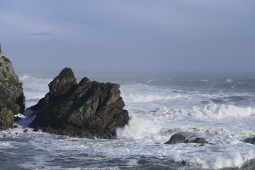 Fototapeta na wymiar Strong surf with rocks and foaming sea on a beach