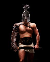 Fototapeta na wymiar Gladiator with sword and armor on a black background