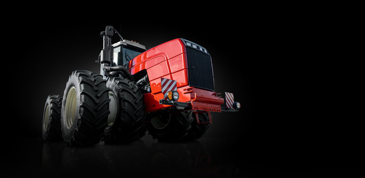 Red agricultural tractor on a black background