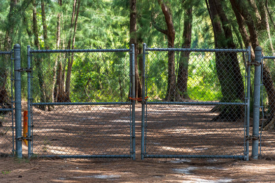 Closed and locked gate, chain link fence, blocking access to park nature trail, during COVID-19 outbreak - Davie, Florida, USA