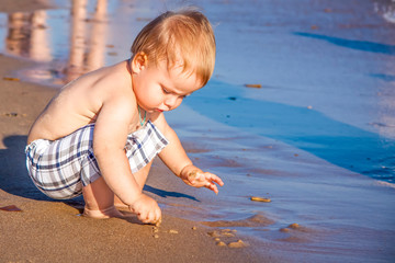 Relaxing on the beach. A child is sunbathing on the sand of the beach. Hot summer day by the sea.