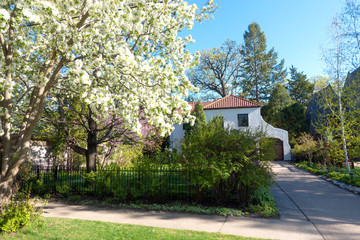Beautiful home with red tile roof and apple tree filled with blossoms. St Paul Minnesota MN USA
