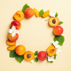 Circle made of apricots on beige background, space for text