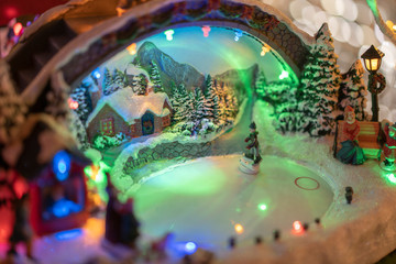 Toy model of a person skating on an ice rink with Christmas decorations