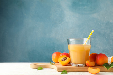 Composition with tasty apricots and juice on wooden table