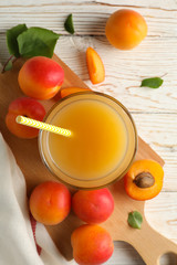 Composition with tasty apricots and juice on wooden background, top view