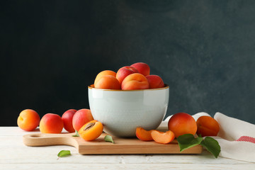 Composition with tasty apricots on wooden table against dark background