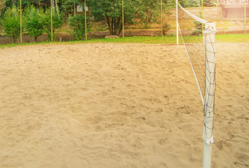 An empty Playground with sand and a volleyball net for playing beach volleyball, sunlight on a...