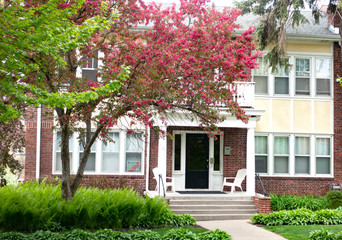 Attractive apartment building with a pink blooming fruit tree and gardens. St Paul Minnesota MN USA