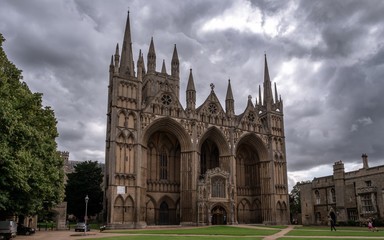 Fototapeta na wymiar The frontage of Peterborough Cathedral with dramatic sky in the background