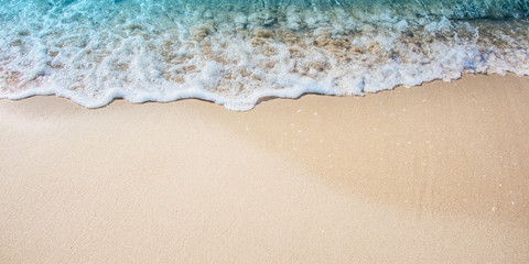 Fototapeta na wymiar Soft Wave Of Blue Ocean On Sandy Beach. Summer background.
