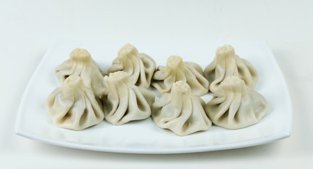 Boiled khinkalis (Georgian dumpling) on a white plate