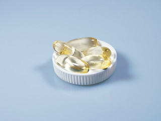 a few capsules with vitamin D in the lid on the table