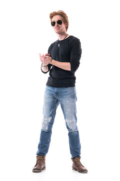Satisfied young man in stylish clothes applauding an looking at camera doing standing ovations. Full body length isolated on white background. 