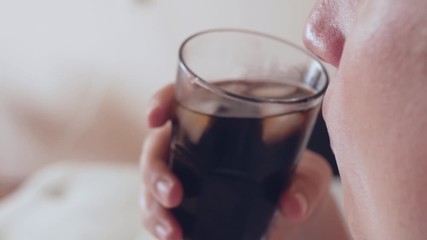 Young fat caucassian man drinks refreshing soda drink