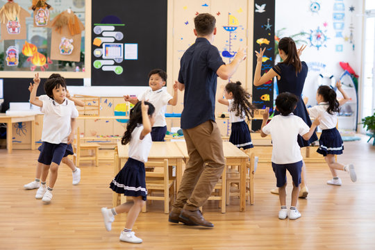 Teachers and children playing games in classroom