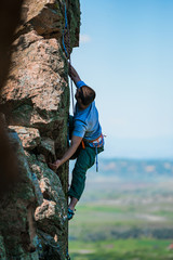 Fototapeta premium Young man finishing his extreme mountain climb