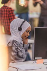 African american muslim girl with hijab and headset working  as customer support in a modern office.