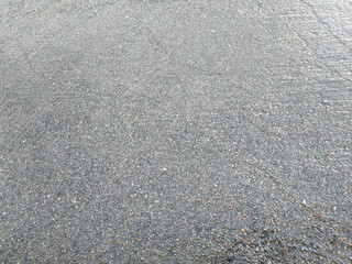 water puddles with raindrops and water circles on cracked wet asphalt road
