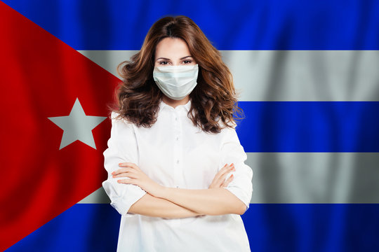 Happy doctor in protective mask against national flag Cuba. Flu epidemic and virus protection concept