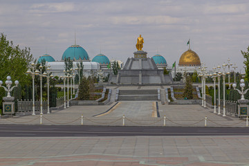 Golden Statue of Saparmurat Niyazov in Ten Years of Independence Park in Ashgabat, capital of Turkmenistan. Oguzkhan Presidential Palace in the background.
