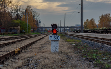 Railway traffic lights standing between rail tracks and showing a red stop signal. Railway lights...