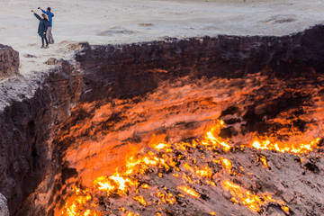 DARVAZA, TURKMENISTAN - APRIL 19, 2018: Couple taking selfies at the Darvaza (Derweze) gas crater...