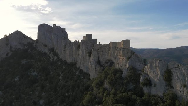 Chateau De Peyrepertuse on top of dramatic rock face, aerial perspective