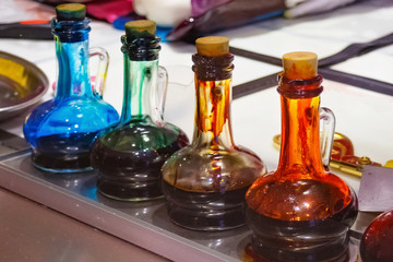 Multicolored glass flasks with various ingredients for the production of candy and other sweet food.