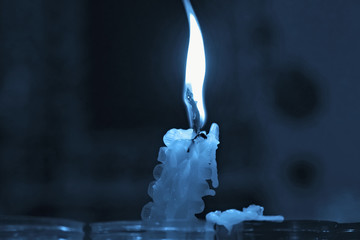 Burning candle on a dark blue background