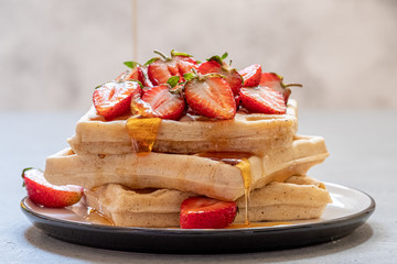waffle breakfast with strawberry and honey maple syrup