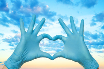Doctor hands showing heart against sky. Help, support, healthy lifestyle, healthcare, medicine and ambulance concept