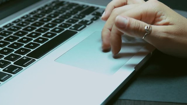 Woman working on laptop  in home office. Female hands typing on laptop.