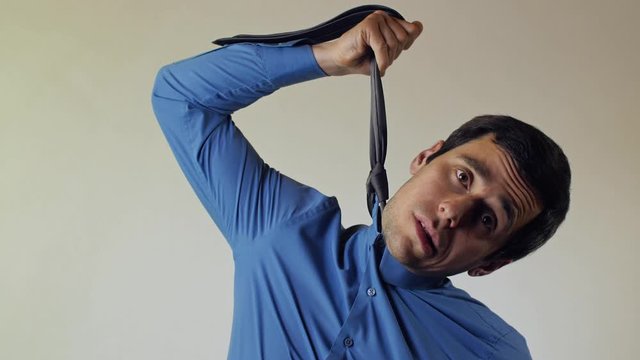 Suicidal businessman strangling himself tie