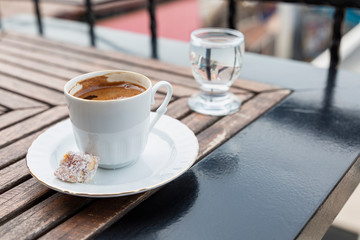 Turkish coffee and a glass of water on a table in a cafe. Space for text. Great start to the day.