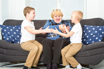 Obraz na płótnie Canvas Grandmother and grandchildren play together. A happy, cheerful family. 