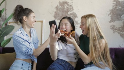 Happy multiethnic friends eating pizza