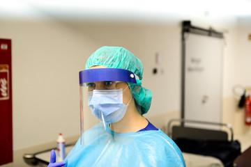 Doctor wearing disposable coverall with mask and safety google in hospital. Pandemic 2019...