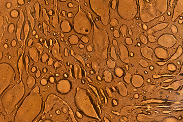 oil spill on terra cotta brown background abstract