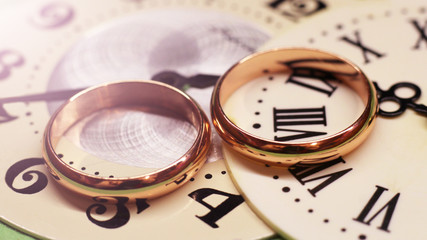 Two wedding rings and a watch with Roman numerals