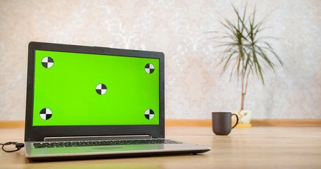 laptop with green screen in the room