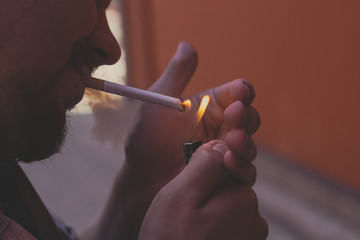 a man lights a cigarette in the evening