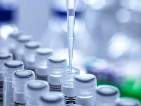 Close-up of pipette filling test tube with human saliva sample