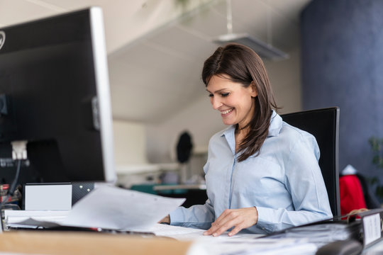 Smiling businesswoman working at desk in office